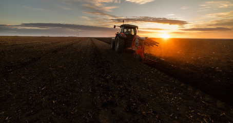Tractor plowing fields in sunset