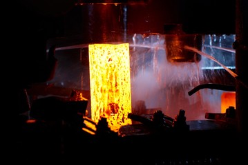 metal forging. hydraulic hammer shapes the red hot billet. the production of high tech parts