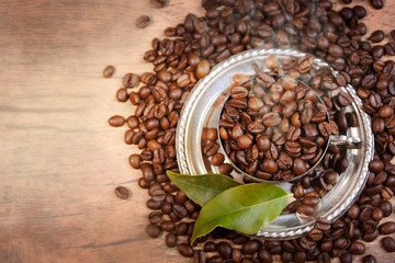 Coffee cup and beans on old kitchen table.