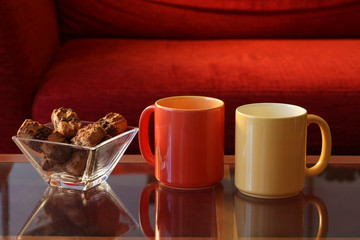 relax concept: two cups of coffee or tea rest on a glass small table and cookies with copy space for your text