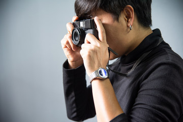 Fototapeta premium Photographer with camera film on grey background.