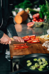 Cooking dinner - Chef Holding a Knife and Cutting Red Bell Pepper