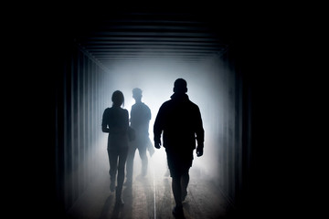 Silhouette of people in a misty tunnel a tunnel