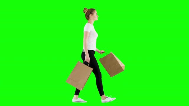 Smiling Young Woman Walking Back From Shopping Holding Paper Bags Green Screen