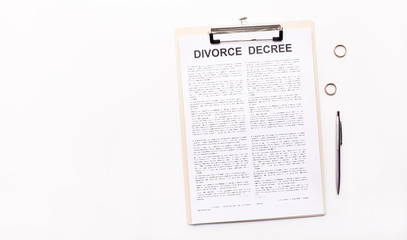 Divorce decree law document, wedding rings and pen