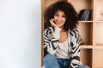 Optimistic beautiful young african woman indoors at home.