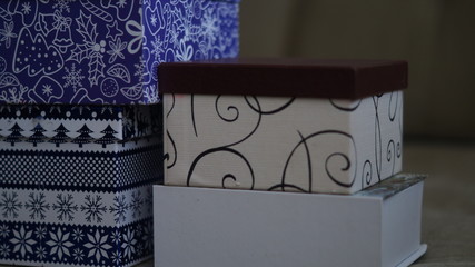 Gift boxes are blue with patterns, light with a brown lid and light in the shape of a book
