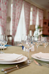 Table set with plates, wineglasses and cutlery on table, copy space. Place setting at wedding reception. Table served for wedding banquet in restaurant