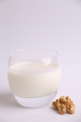 glass of walnut milk in color background