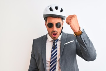 Young handsome business man wearing bike helmet and sunglasses over isolated background annoyed and frustrated shouting with anger, crazy and yelling with raised hand, anger concept