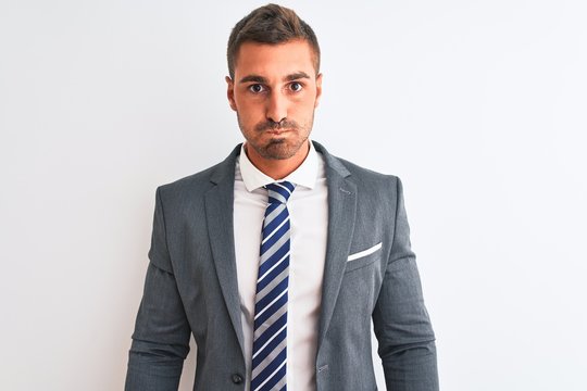 Young handsome business man wearing suit and tie over isolated background puffing cheeks with funny face. Mouth inflated with air, crazy expression.