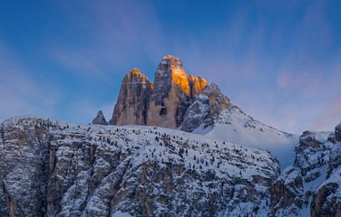 Colorful sunset sunset in Dolomites mountains, three peaks of Tre Cime di Lavaredo in snowy and...