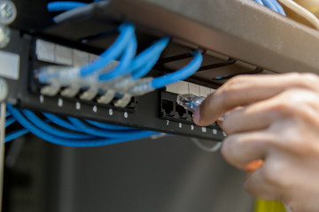 hand with network cables connected to servers in a datacenter.