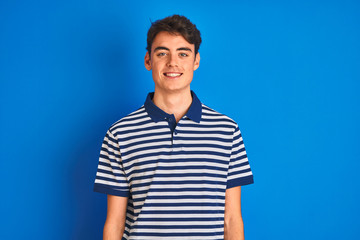 Obraz premium Teenager boy wearing casual t-shirt standing over blue isolated background with a happy and cool smile on face. Lucky person.