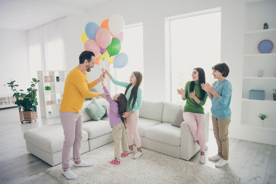 Full length photo positive fun people dad daddy mom mommy prepare air baloons woman family day celebration three preteen small kids clap hands ovation sit comfort couch house