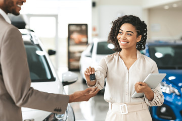 Lady Dealer Selling Car To Businessman Giving Key In Store
