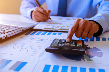 business man people working analyzing and calculate summary of cost from document chart and graph with calculator at office, Accounting and finance in the office.