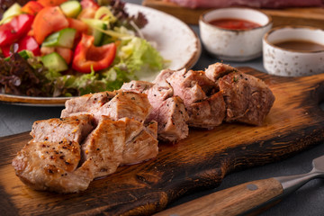 Bbq slices meat on a wooden board. Closeup