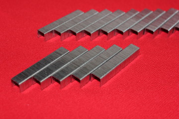  Staples for a stapler are exposed on a red background. Staples isolated on red background