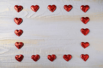 Valentines Day background with red hearts on a wooden table, top view. Copy space. Top view