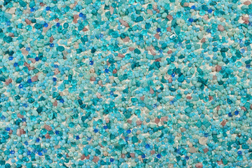 Texture of various jewels on a white background. Blue, aquamarine and purple stones. Beads and necklaces are glued to the wall.