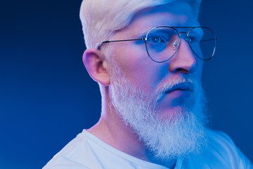 Serious albino man under blue light - obrazy, fototapety, plakaty