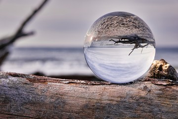 Lensball as the subject on a piece of driftwood during a beautiful sunset at the beach