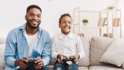 Happy afro dad enjoying video game with his cute daughter © Prostock-studio