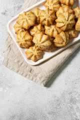 Lemon cookies with poppy seeds in a white ceramic bowl on the gray kitchen table. Shortbread. Top view with a copy of the space