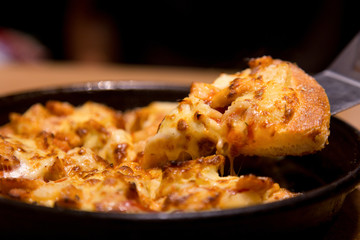 Hot pizza slice with melting cheese on a  table in restaurant pizza Italian food.