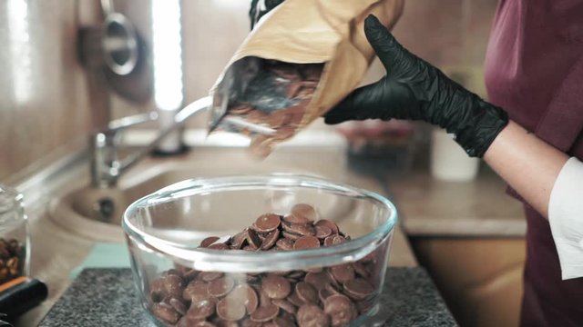 Circle chocolate candy melts pouring into the glass container