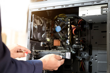 Technician with a screwdriver for fixing computers, computer har;