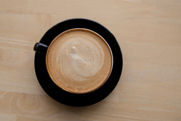 Cup of coffee latte on wooden background. Top view.