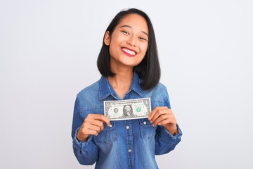 Young beautiful chinese woman holding one dollar standing over isolated white background with a happy face standing and smiling with a confident smile showing teeth