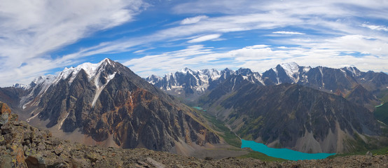 A large mountain lake of turquoise color in sunny weather. In the background are high mountains with glaciers. Mountains are reflected in the water. photo from a great height, Earth day.