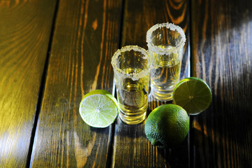 Alcoholic drink concept. Mexican tequila with lime and salt on rustic wood background. space for text. concept luxury drink.Two shots tequila with lime and salt on wooden table.
