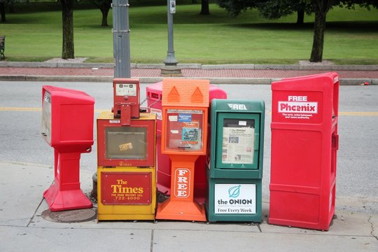 PROVIDENCE, USA - JUNE 8, 2013: Newspaper dispensers in Providence, Rhode Island. Available press titles include The Times, The Onion and The Phoenix free paper.