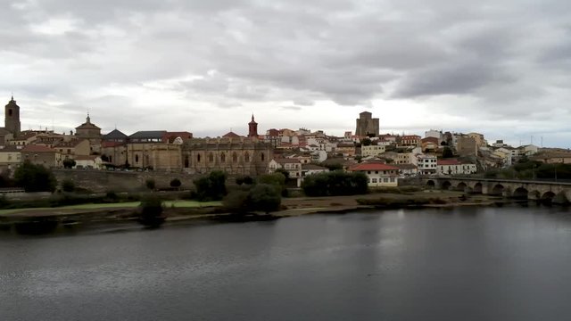 Beautiful panoramic view of historic city Alba de Tormes, Castilla y Leon region, Spain. Ancient city on riverfront in a cloudy day. Pan from left to right