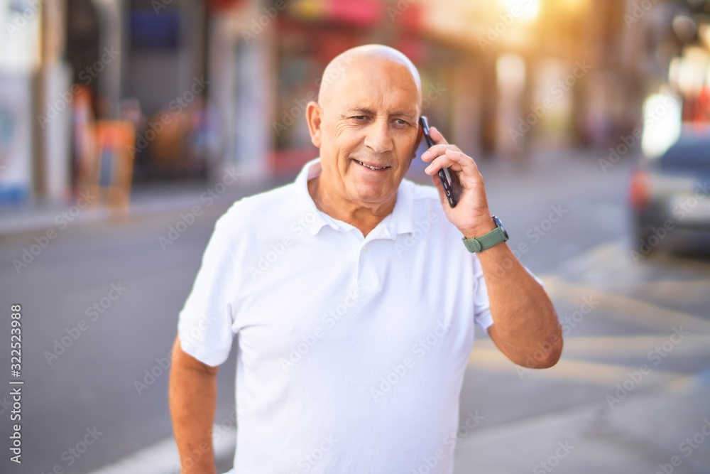 Wall mural senior handsome man smiling happy and confident. standing with smile on face talking by the phone at