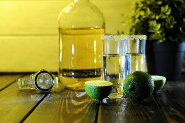 Alcoholic drink concept. Mexican tequila with lime and salt on rustic wood background. space for...