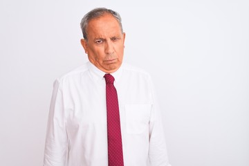 Senior grey-haired businessman wearing elegant tie over isolated white background skeptic and nervous, frowning upset because of problem. Negative person.