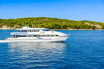 Fototapeta na wymiar Beautifull seascape with small ship - motor boat or luxury yacht cruising on the sea at the coast of island on Adriatic Sea in Croatia, green paradise, islands Kornati