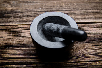 Stone mortar with pestle on black background