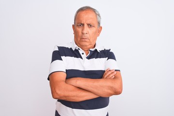 Senior grey-haired man wearing casual striped polo standing over isolated white background skeptic and nervous, disapproving expression on face with crossed arms. Negative person.