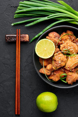 Chicken Karaage in black bowl at dark slate background. Karaage is traditional japanese cuisine dish with deep fried marinated chicken. Top view