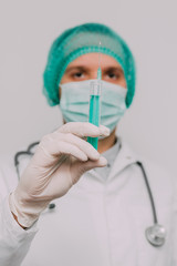 Male doctor with syringe and stethoscope.  Coronavirus epidemic concept.