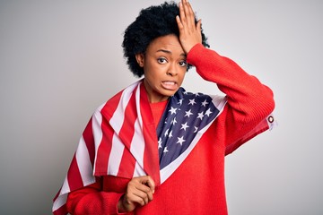 Young African American afro woman with curly hair wearing united states of america flag stressed with hand on head, shocked with shame and surprise face, angry and frustrated. Fear and upset