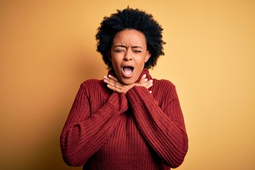 Fototapeta na wymiar Young beautiful African American afro woman with curly hair wearing casual turtleneck sweater shouting suffocate because painful strangle. Health problem. Asphyxiate and suicide concept.
