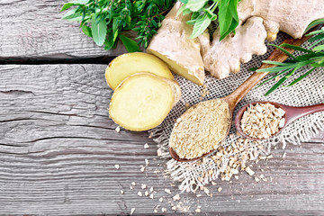 Ginger ground and flakes in spoons with root on board top