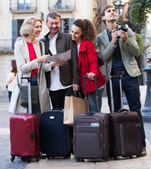 Portrait of tourists with map and baggage seeing the sights in European city